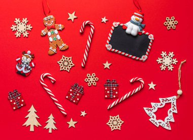 Kırmızı arka planda Noel tatili kompozisyonu. Noel dekoratif tebrik kartı. Boşluğu kopyala, düz yat, üst görünüm.