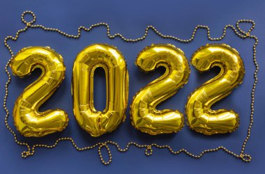 2022 altın şişirilebilir rakam mavi arka planda. Yeni yıl konsepti
