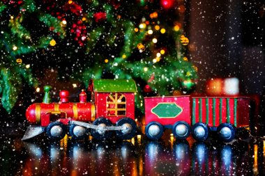 Noel oyuncak treni şık bir şekilde dağılmış Noel ağacında ve arka planda ışıklar