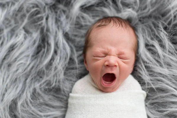 Neugeborenes Liegt Gähnend Kleines Kind Auf Grauem Fell Liegend Ein — Stockfoto