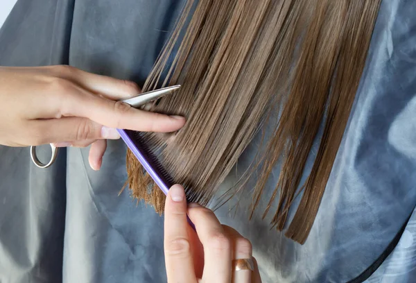 Detailní záběr ženy ruce stříhání mokré dlouhé vlasy s nůžkami — Stock fotografie