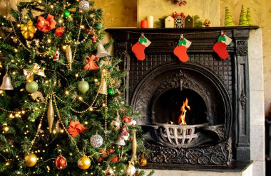 Yanan bir şöminenin yanında süslenmiş Noel ağacı. Noel evi dekorasyonu