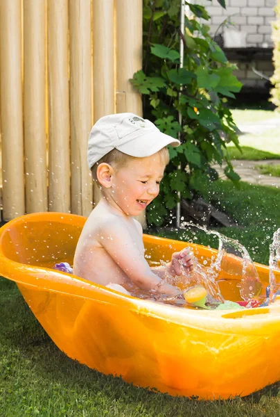 Kleinkind planscht an einem sonnigen Sommertag im Freien in der Wanne — Stockfoto