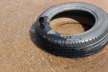 Bir nehir kıyısında eski lastik