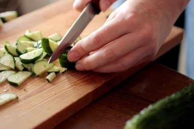 kadının elinde bir salatalık Dilimleme