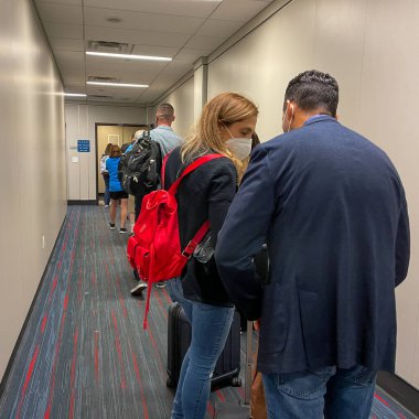 Orlando FL USA - 26 Eylül 2021: Orlando, Florida 'daki Orlando Uluslararası Havaalanı' nda bir Amerikan uçağına binmek için jet yolunda bekleyenler.