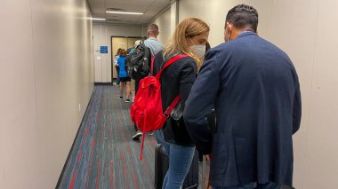 Orlando FL USA - 26 Eylül 2021: Orlando, Florida 'daki Orlando Uluslararası Havaalanı' nda bir Amerikan uçağına binmek için jet yolunda bekleyenler.