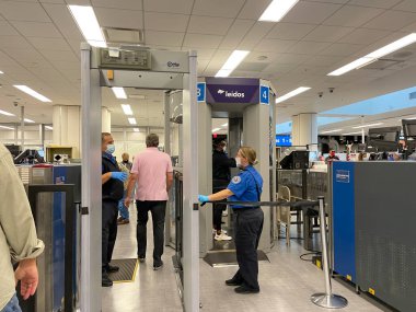 Orlando, FL USA - 23 Eylül 2021: Orlando Uluslararası Havalimanı MCO 'daki güvenlik sınırında yürüyen insanlar.