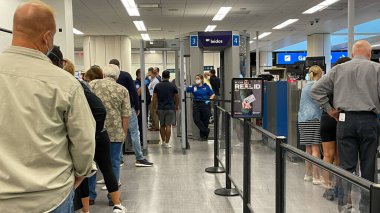 Orlando, FL USA - 23 Eylül 2021: Orlando Uluslararası Havalimanı MCO 'daki güvenlik sınırında yürüyen insanlar.