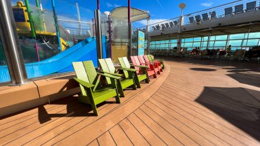 Orlando, FL USA-6 Aralık 2021: Royal Caribbean RCL yolcu gemisi Independence of the Seas in Port Canaveral, Florida 'daki aile havuzunda renkli sandalyeler.