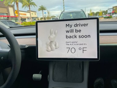 Orlando, FL ABD-19 Kasım 2021: Otoparktayken araba sahipleri köpek yoldaşlarının klimalarını açık tutmak için bir Tesla köpek moduna girdi.
