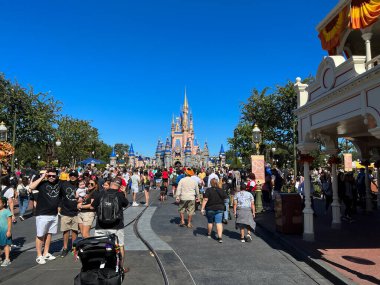 Orlando, FL USA - 30 Ekim 2021: Orlando, Florida 'daki Walt Disney World Magic Kingdom' daki Külkedisi Kalesi 'ne doğru yürüyen insanlar.