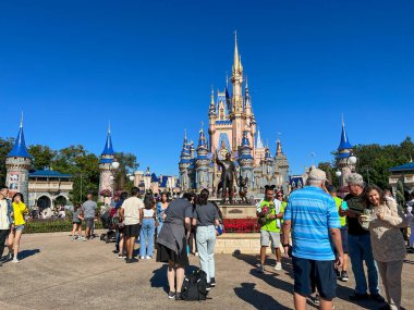 Orlando, FL USA - 2 Aralık 2021: İnsanlar Noel boyunca Orlando, Florida 'daki Walt Disney World Magic Kingdom' da Cinderella Şatosu 'na doğru yürüyorlar.
