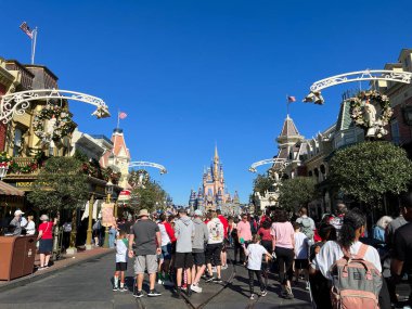 Orlando, FL USA - 2 Aralık 2021: İnsanlar Noel boyunca Orlando, Florida 'daki Walt Disney World Magic Kingdom' da Cinderella Şatosu 'na doğru yürüyorlar.