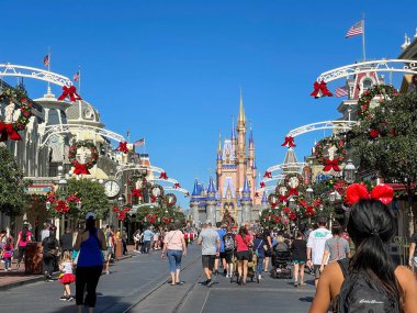 Orlando, FL USA - 25 Kasım 2020: İnsanlar Noel boyunca Orlando, Florida 'daki Walt Disney World Magic Kingdom' da Cinderella Kalesi 'ne doğru yürüyorlar.