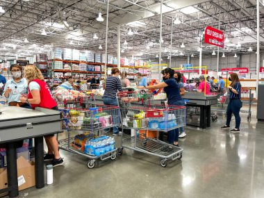 Orlando, FL USA - 6 Haziran 2021: Costco bakkal kasasında çeşitli müşterileri kontrol eden çalışanlar.