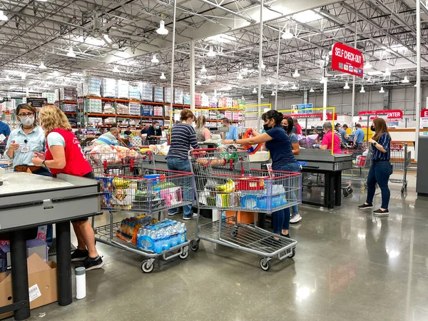 Orlando, FL USA - 6 Haziran 2021: Costco bakkal kasasında çeşitli müşterileri kontrol eden çalışanlar.