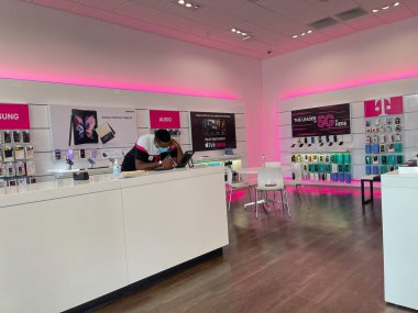 Orlando, FL USA - 19 Ekim 2021: Bir T-Mobile çalışanı Orlando, Florida 'da bir T-Mobile mağazasında müşteriye yardım ediyor.