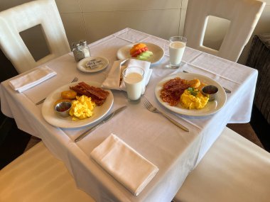 Port Canaveral, FL USA - 13 Ocak 2022: Bir yolcu gemisinde bir restoranda çırpılmış yumurta, pastırma ve süt kahvaltısı.