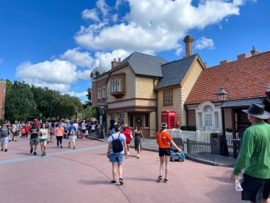 Orlando, FL USA- 9 Ekim 2021: Orlando, Florida 'daki Walt Disney World' de Birleşik Kindgom bölgesinde yürüyen insanlar.