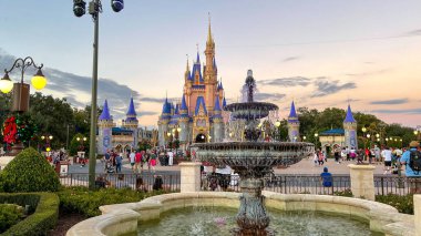 Orlando, FL USA - 25 Kasım 2020: İnsanlar Noel boyunca Orlando, Florida 'daki Walt Disney World Magic Kingdom' da Cinderella Kalesi 'ne doğru yürüyorlar.