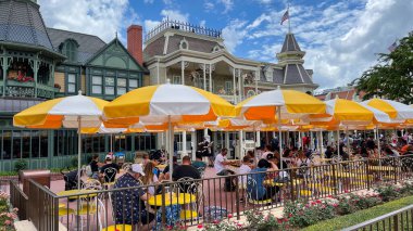 Orlando, FL USA - 5 Temmuz 2021: İnsanlar Orlando, Florida 'da Walt Disney World Magic Kingdom' da açık bir kafede yemek yiyorlar.