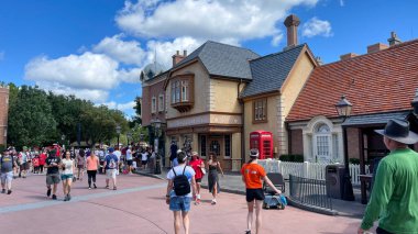 Orlando, FL USA- 9 Ekim 2021: Orlando, Florida 'daki Walt Disney World' de Birleşik Kindgom bölgesinde yürüyen insanlar.