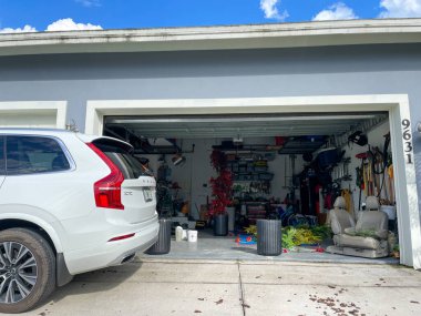 Orlando, FL USA - 10 Temmuz 2021: Bir mahallede bir sürü eşyayla dolu düzensiz bir garaj.