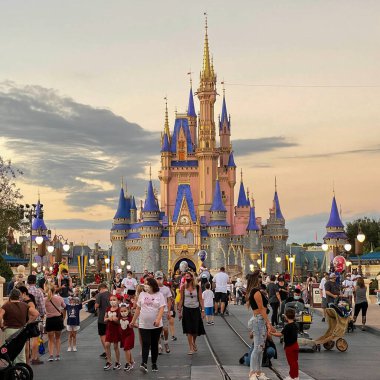 Orlando, FL USA - 27 Kasım 2020: Orlando, Florida 'daki Walt Disney World Magic Kingdom' da Noel boyunca Külkedisi Kalesi 'ne doğru yürüyen insanlar.