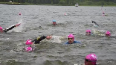 Dalgıç kıyafetli sporcular yüzmede yarışıyorlar.