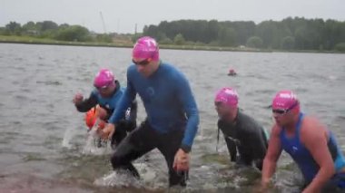 Dalgıç kıyafetli sporcular yüzmede yarışıyorlar.