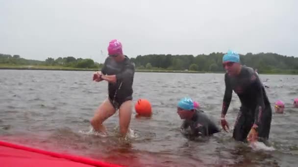 Спортсмены в гидрокостюмах соревнуются в плавании — стоковое видео