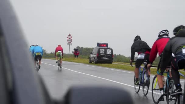 Triathloniści ścigają się na mokrej drodze — Wideo stockowe