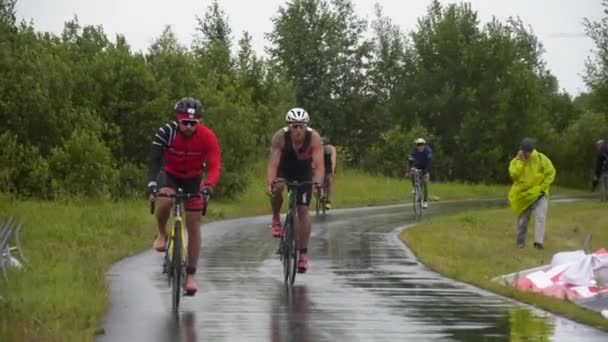 Triathletes racing on wet road — Stock Video