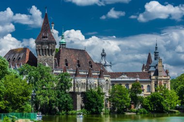 The famous tourist attraction Vajdahunyad Castle with lake over the blue sky in main City Park. Budapest, Hungary.