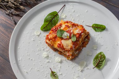 Bloody Sorrel ve Parmesan, Pecorino Romano ve Mozzarella ile etli lazanya. Görüntü editoryal ya da ticari olarak kullanılabilir.