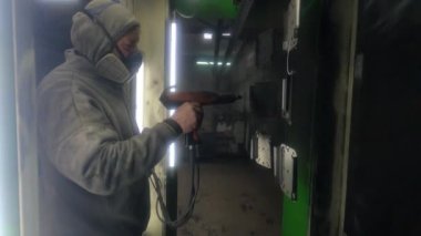 Bila Tserkva, Ukrayna, Mart 2021: İşçi bir fabrikada metal parçaları boyuyor