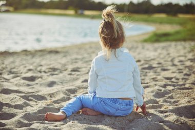 Charming child walking on the beach at sunset. High quality photo