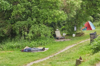 Kopenhag, Danimarka, Mayıs 2022: Özgür Christiania şehrindeki bir çimenlikte uyuyan evsiz adam