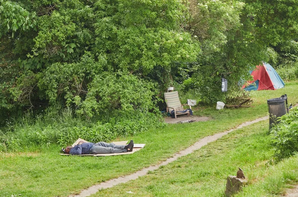 Kopenhag, Danimarka, Mayıs 2022: Özgür Christiania şehrindeki bir çimenlikte uyuyan evsiz adam
