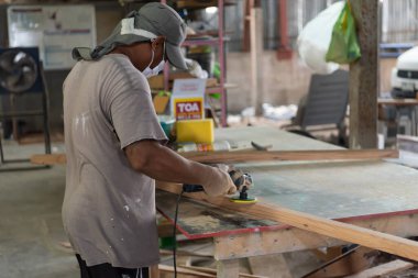 Bangkok, Tayland - 1 Mayıs 2020: Tanımlanamayan marangoz, depodaki doğal ahşaptan mobilya ya da kereste ya da ahşap fabrikasından inşaat ya da satış için kereste üretiyor.