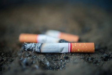 Sigara dışarıda kül tablasında yanıyor sigara bağımlılık yapan nikotinden sağlıksız ve tehlike kavramından