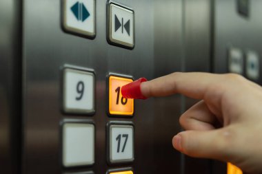İnsanlar asansörde dokunmak için düğmeye bastığında parmak kalkanı takıyorlar. Salgın hastalığa karşı korunmak için. Covid19 ya da Corona virüsü.