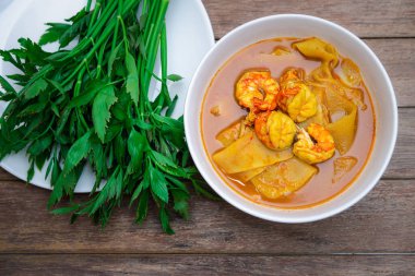Tayland baharatlı baharatlı, karides ve karidesli sarı köri ve sebzelerle yenmiş bambu filizi (Gaaeng Leuang) veya Tayland restoranında satılık Oenanthe.