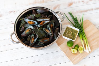 Haşlanmış ya da buğulanmış midye birinci sınıf deniz ürünleri, deniz ürünleri soslu (acılı, sarımsaklı, limonlu), Bangkok 'taki Tayland sokak yiyecek pazarında ya da restoranda satılık beyaz masada ekşi ve baharatlı.