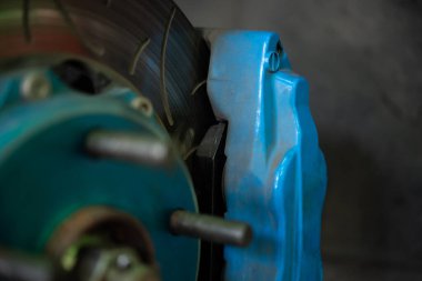 Araba tamircisi ya da tamirci araba tamirhanesinde ya da tamirhanede tamir ve onarım sorunları için disk freni ve asbest fren pedlerini kontrol ediyor.