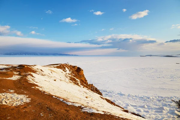 Lago Baikal no inverno. Um lago gelado coberto de neve. Céu bonito, nuvens. — Fotografia de Stock