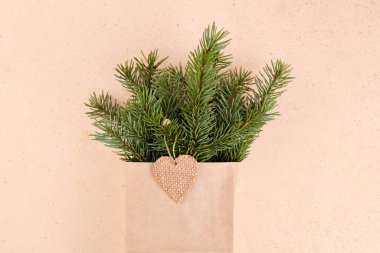 El çantasındaki ladin dallarından oluşan kış buketi. El işi kağıdında çevre dostu ambalaj. Üst görünüm.