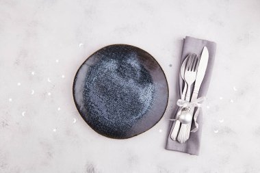 Noel ya da yeni yıl sofrası. Tabak, gümüş çatal bıçak, açık gri arka planda dekor.. 