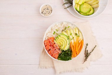 Somon, pirinç, avokado, mango, yosun, havuç, susam tohumu ve soya sosuyla karıştırın.. 